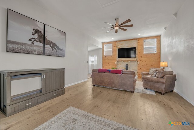 living room featuring ceiling fan, plenty of natural light, and light wood-type flooring