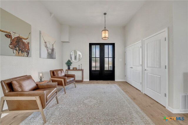 foyer entrance with light hardwood / wood-style floors and french doors