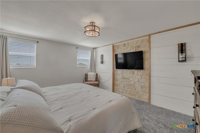 bedroom with wood walls and carpet flooring