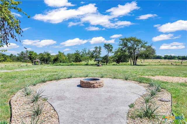 view of patio with a rural view and a fire pit