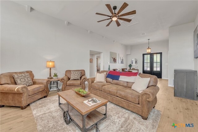 living room featuring french doors, light wood-type flooring, and ceiling fan