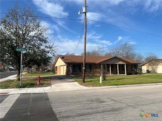 ranch-style house with a garage, a front lawn, concrete driveway, and brick siding