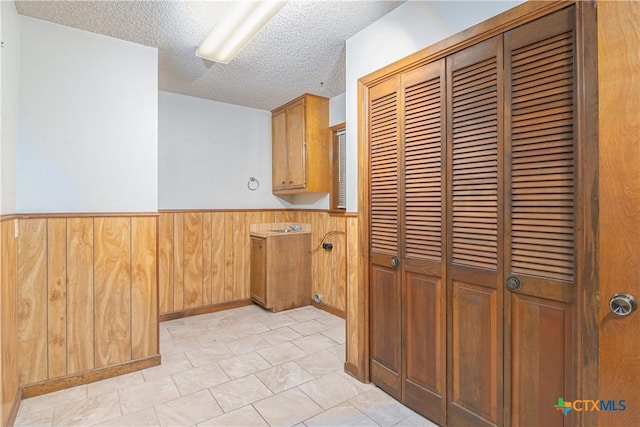 kitchen with a textured ceiling and wood walls