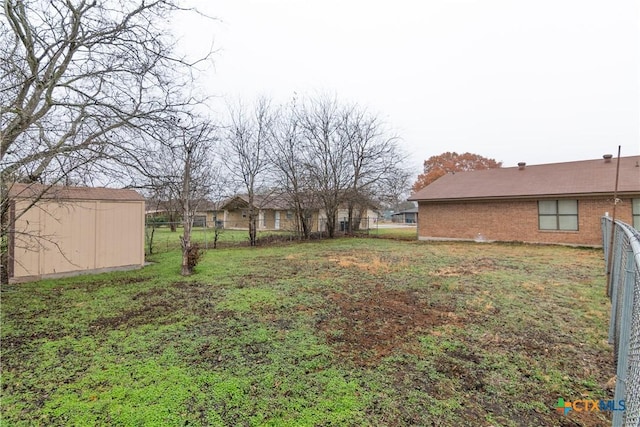 view of yard featuring an outdoor structure, a storage shed, and fence