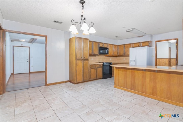 kitchen with an inviting chandelier, a textured ceiling, hanging light fixtures, kitchen peninsula, and black appliances