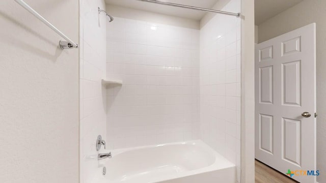 bathroom featuring hardwood / wood-style floors and tiled shower / bath