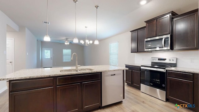 kitchen with decorative light fixtures, an island with sink, sink, stainless steel appliances, and dark brown cabinets