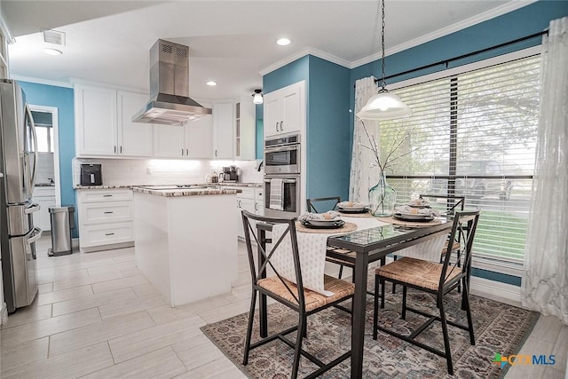 kitchen with appliances with stainless steel finishes, a center island, island range hood, white cabinets, and decorative backsplash