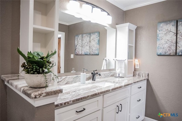 bathroom with vanity, a textured wall, and crown molding