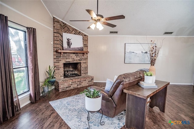 living area featuring vaulted ceiling, a textured ceiling, ceiling fan, visible vents, and wood finished floors