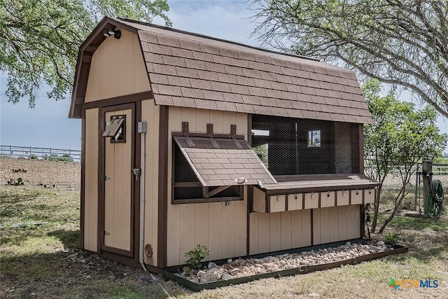 view of outbuilding with an outdoor structure and fence
