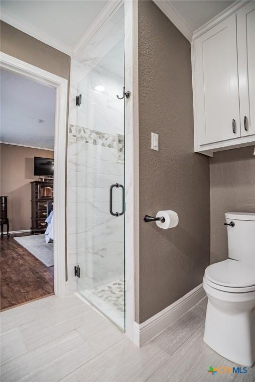 full bath featuring a stall shower, crown molding, toilet, and a textured wall