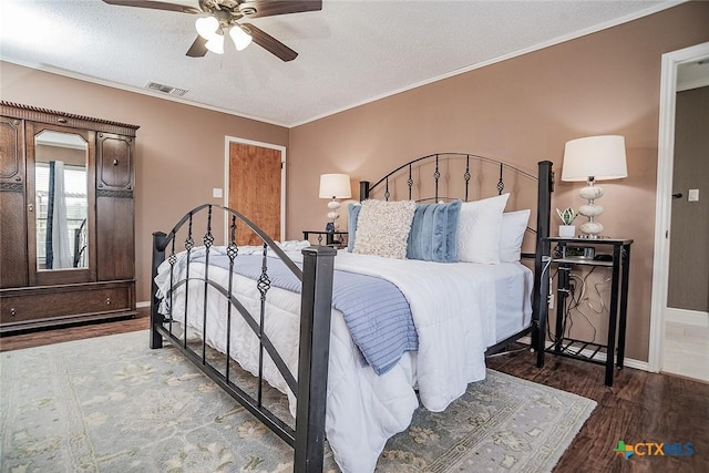 bedroom featuring crown molding, baseboards, a textured ceiling, and wood finished floors