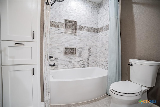 full bath with shower / bath combo, a textured wall, toilet, and tile patterned flooring