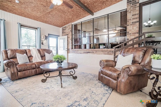 living room featuring ceiling fan with notable chandelier and beam ceiling
