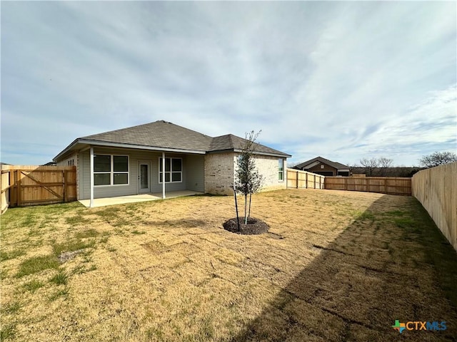 rear view of house featuring a patio and a yard