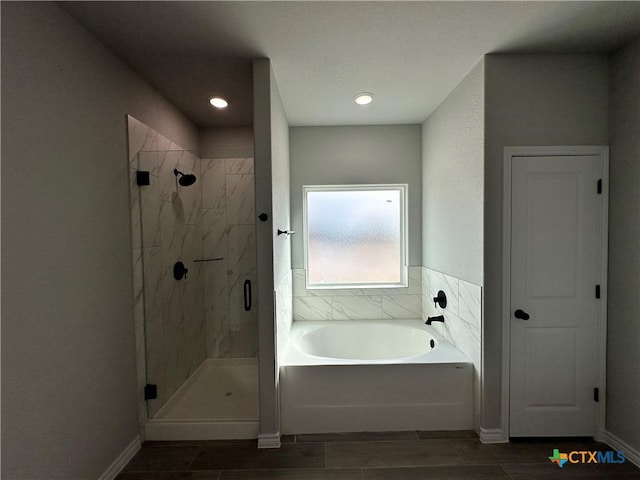 bathroom featuring independent shower and bath