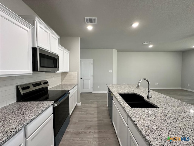 kitchen with sink, white cabinets, light stone countertops, dark hardwood / wood-style floors, and black appliances