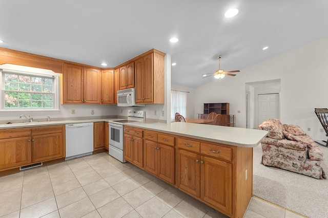 kitchen with white appliances, sink, vaulted ceiling, ceiling fan, and kitchen peninsula