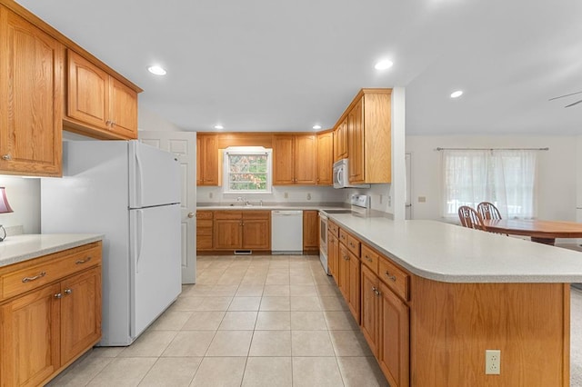 kitchen featuring kitchen peninsula, white appliances, ceiling fan, sink, and light tile patterned flooring