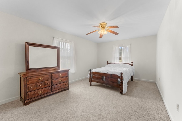 carpeted bedroom featuring multiple windows and ceiling fan