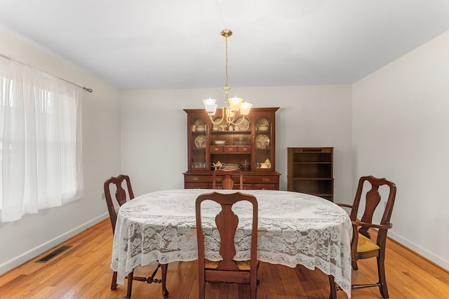 dining area with a chandelier, light wood-type flooring, and a wealth of natural light