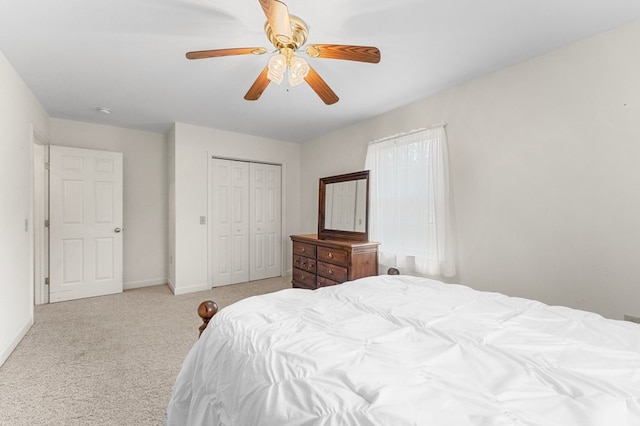 bedroom with ceiling fan, light colored carpet, and a closet