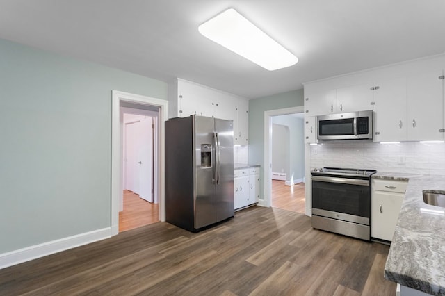 kitchen featuring dark wood-type flooring, white cabinets, decorative backsplash, appliances with stainless steel finishes, and light stone counters