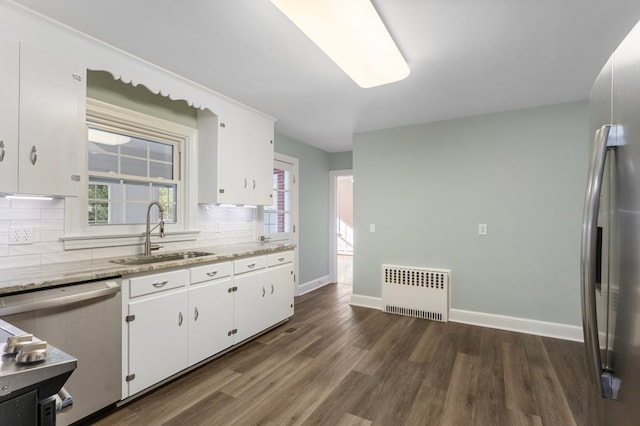 kitchen featuring radiator, white cabinetry, sink, and stainless steel dishwasher