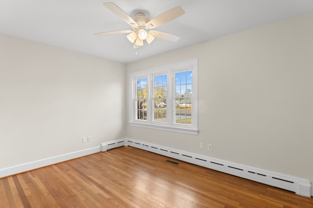 spare room featuring baseboard heating, ceiling fan, and light hardwood / wood-style floors