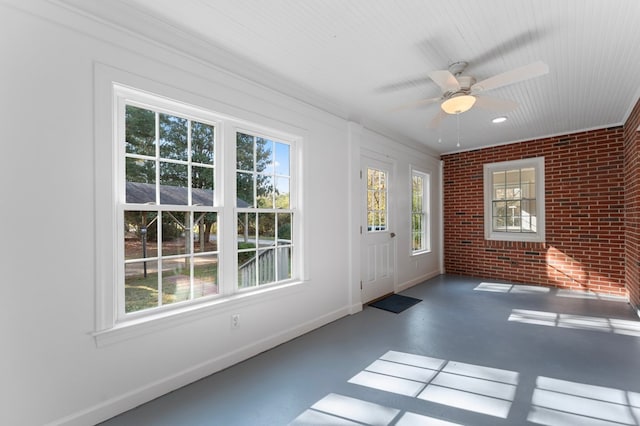 unfurnished sunroom with ceiling fan and a healthy amount of sunlight