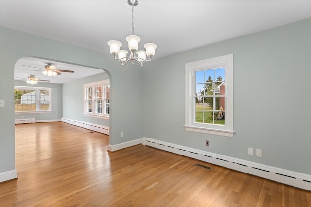 spare room with a baseboard radiator, ceiling fan with notable chandelier, and hardwood / wood-style flooring