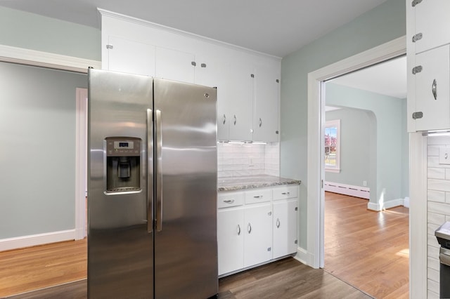 kitchen with backsplash, a baseboard heating unit, stainless steel refrigerator with ice dispenser, dark hardwood / wood-style flooring, and white cabinetry