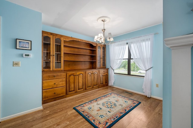 dining area with hardwood / wood-style floors and a notable chandelier