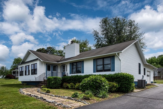 view of front of home with central AC unit and a front yard