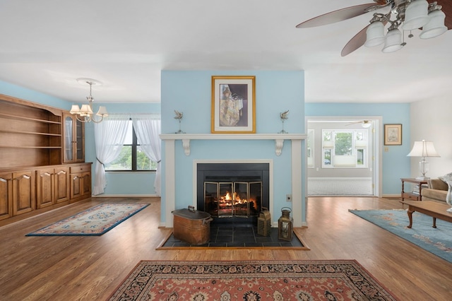 living room featuring wood-type flooring and ceiling fan with notable chandelier