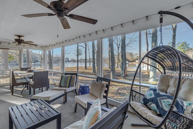 sunroom / solarium featuring a water view and ceiling fan