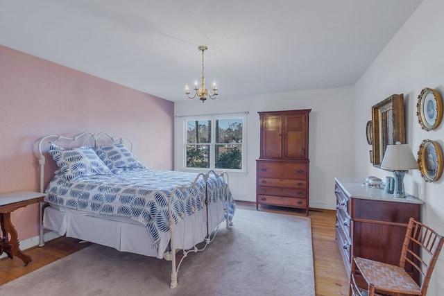 bedroom featuring a chandelier and light hardwood / wood-style floors