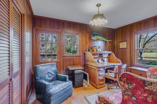 office space with light hardwood / wood-style floors, crown molding, and wood walls