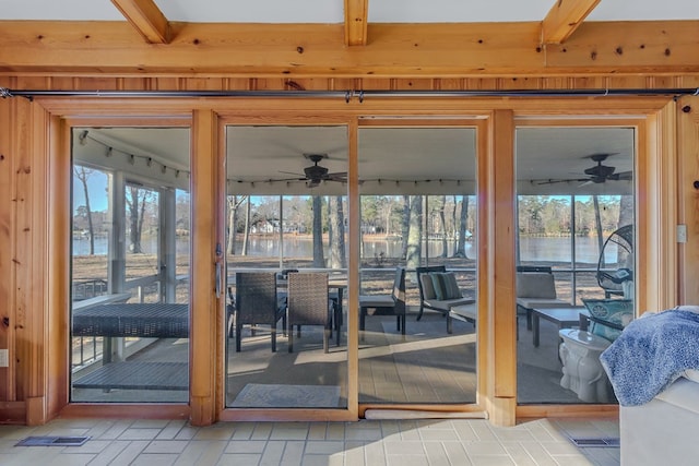 doorway to outside with beam ceiling, a water view, a wealth of natural light, and ceiling fan