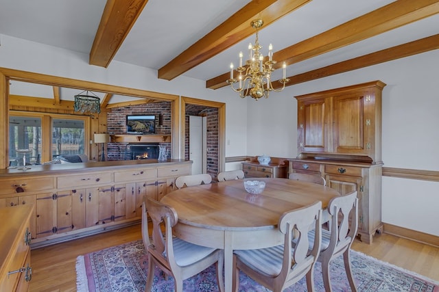 dining room featuring beamed ceiling, a chandelier, and light wood-type flooring