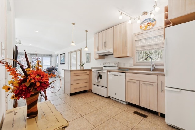 kitchen featuring white appliances, light tile patterned floors, visible vents, a sink, and under cabinet range hood