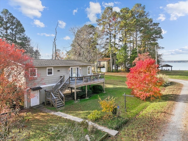 rear view of property featuring a yard, a wooden deck, and stairs