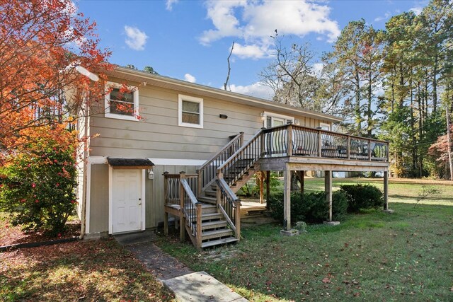 back of property featuring a lawn, a deck, and stairs