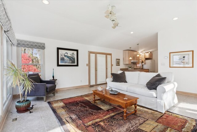 living area with vaulted ceiling, light tile patterned flooring, recessed lighting, and baseboards