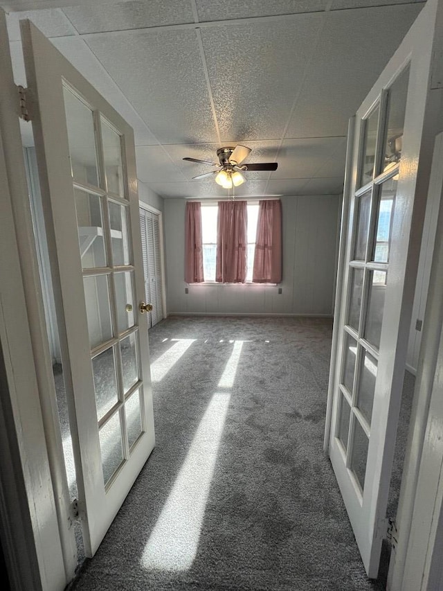 empty room featuring carpet, french doors, and ceiling fan