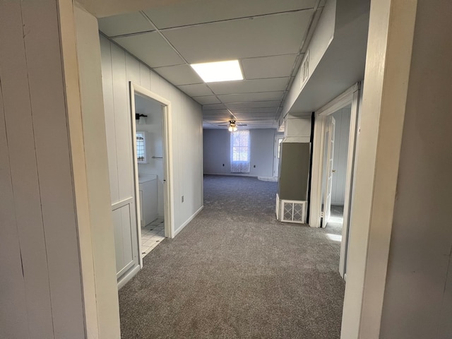 corridor featuring carpet and a drop ceiling