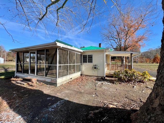 rear view of house with a sunroom and a deck