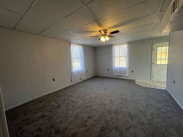 carpeted empty room featuring a drop ceiling and ceiling fan