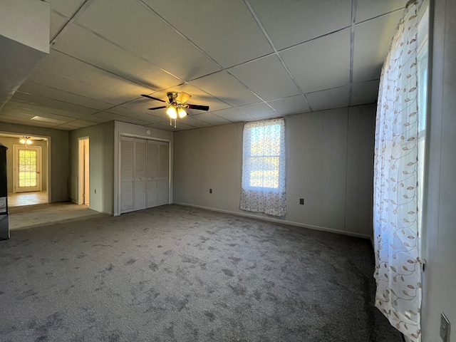 unfurnished bedroom with carpet floors, ceiling fan, and a paneled ceiling